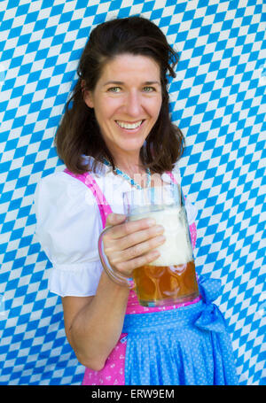 Porträt einer Frau im Dirndl hält ein Bierkrug Stockfoto