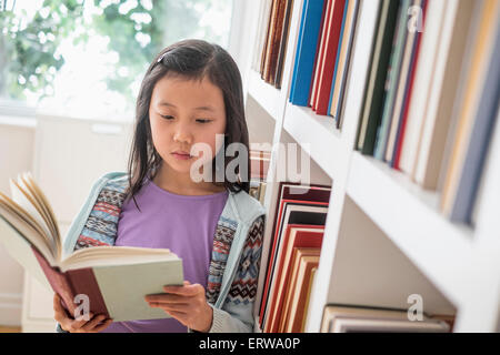 Chinesischer Student Buch in der Nähe von Bibliothek Bücherregal Stockfoto