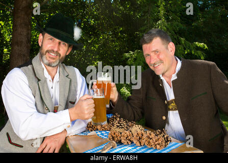 zwei bayerische Männer sitzen in einem Park und trinken Bier Stockfoto