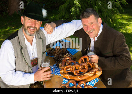 zwei bayerische Männer sitzen in einem Park und trinken Bier Stockfoto