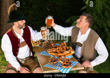 zwei bayerische Männer sitzen in einem Park und trinken Bier Stockfoto