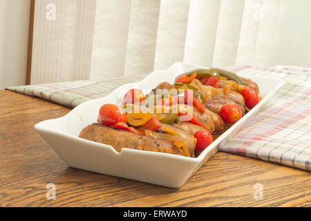 Heiße italienische Bratwürste mit in Scheiben geschnittenen Paprika und Zwiebeln Stockfoto