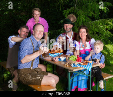bayerischen Familie draußen auf einer Bank und trinken Bier Stockfoto