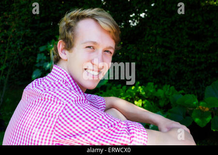 Porträt eines jungen blonden Mannes in einem park Stockfoto