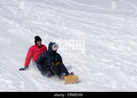 Zwei Frauen lachen auf einem Schlitten Stockfoto