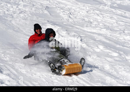 Zwei Frauen lachen auf einem Schlitten Stockfoto