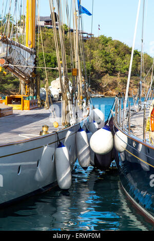 Klassische Yachten und Kotflügel vor Anker in Falmouth, Antigua mit Villen im Hintergrund Stockfoto