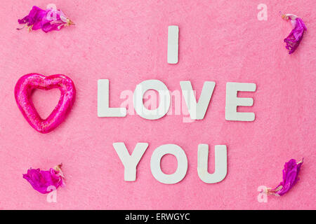 Ich liebe dich Wörter mit einem Purple Heart und Blütenblätter Stockfoto