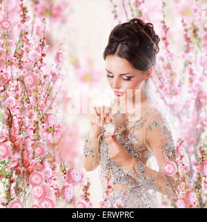 Frau mit Parfüm über Blumenkarte Stockfoto