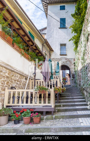 Alte steinerne Treppe mit Geländer in einer Straße in der Altstadt von einem Dorf in der Landschaft der Romagna Stockfoto