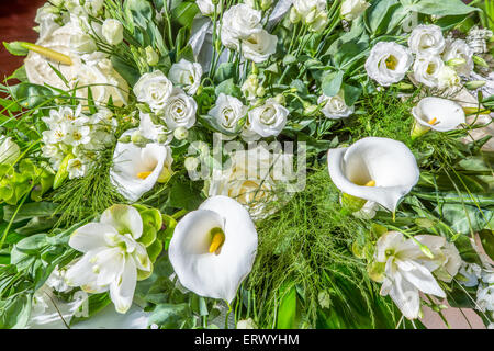 Bouquet von weißen und gelben Blumen, Rosen, Calla-Lilien und grünen Blättern Stockfoto