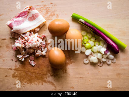 Schinken, Speck, Eiern, Lauch auf einem Holzdeck als Zutaten für ein Frühstück Stockfoto