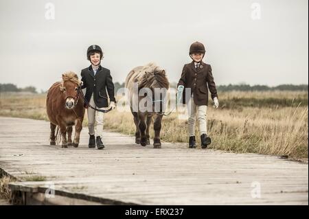 Kinder mit Shetland-Ponys Stockfoto