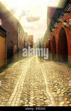 Die Strahlen der Sonne für über einer alten Festungsmauer in der breiten Straße des alten Bruschatoy Riga. Lettland Stockfoto