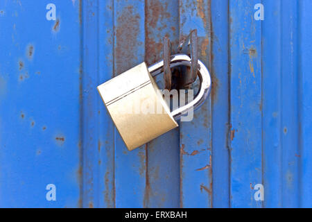 Vorhängeschloss auf alte blaue Metalltür Stockfoto
