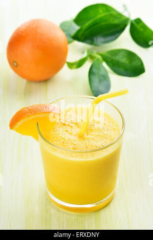 Citrus orange Smoothie im Glas am grünen Tisch Stockfoto