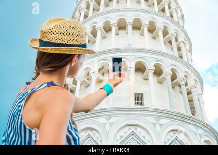 Fotos sind so viel Spaß, vor allem, wenn Sie im Urlaub sind. Frau von hinten nehmen Foto der schiefe Turm von Pisa zu sehen Stockfoto