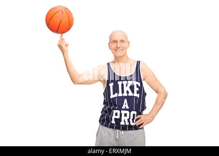 Älteren Mann in einem dunklen blauen Trikot Spinnen einen Basketball an seinem Finger und schaut in die Kamera, die isoliert auf weißem Hintergrund Stockfoto