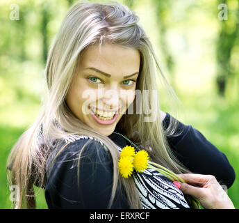 junge schöne Frau mit Löwenzahn Natur Hintergrund Stockfoto