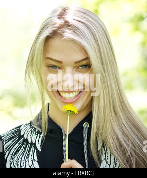 glücklich lächelnde Frau mit Löwenzahn Blume Natur Hintergrund Stockfoto