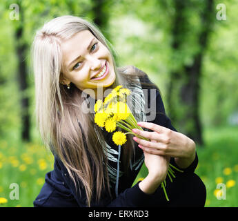 glücklich lächelnde Frau mit Löwenzahn Blume Natur Hintergrund Stockfoto