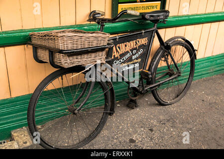 Oldtimer Fahrrad für die Lebensmittel und Brot auf der Plattform des Horsted Keynes Bahnhof, West Sussex, England, UK. Stockfoto