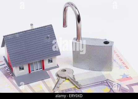 Bild zeigt eine Miniatur-Haus mit einer offenen Vorhängeschloss auf rund Euro-Banknoten Stockfoto