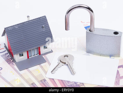 Bild zeigt eine Miniaturhaus mit einer offenen Vorhängeschloss auf rund Euro-Banknoten Stockfoto