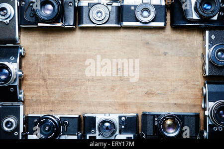 Alten Retro-Analogkameras Filmsammlung auf Vintage Schreibtisch aus Holz, abstrakten Hintergrund, Rahmen, Rahmen Stockfoto