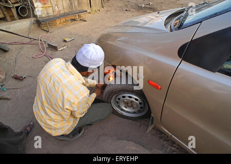 Mann, der Schweißarbeiten am Auto repariert; Sangamner; Ahmednagar, Maharashtra; Indien, asien Stockfoto