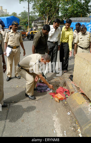 Polizeibeamte untersuchen ein nicht identifiziertes Paket für vermutete grobe Bombe in der Nähe der Chinchpokli-Station in Bombay Mumbai Maharashtra Indien Stockfoto