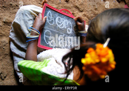 Tribal Mädchen lernen in der Schule, geführt von NGO-Non Government Organization in Dorf in Andhra Pradesh Telugu Alphabete; Indien Stockfoto