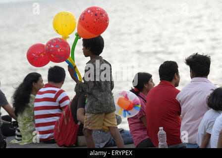 Kleiner Junge verkauft bunte Ballons an Touristen, die Marine Drive in Bombay Mumbai; Maharashtra; Indien Stockfoto