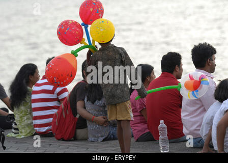 Kleiner Junge verkauft bunte Ballons an Touristen, die Marine Drive in Bombay Mumbai; Maharashtra; Indien Stockfoto