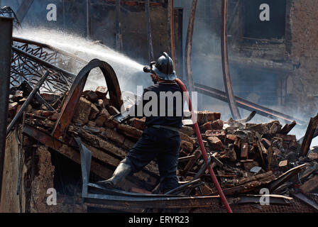 Feuerwehrmann übertüncht Feuer, Behrampada Slums Feuer, Bandra, Bombay, Mumbai, Maharashtra, Indien, Asien Stockfoto
