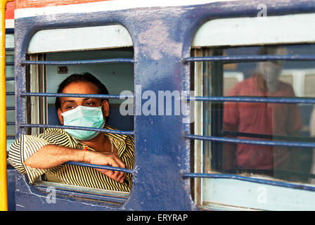 Mann trägt Maske zum Schutz vor Viren im Lokalzug; Bombay; Mumbai; Maharashtra; Indien; Asien Stockfoto