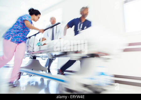 Ärzte und Krankenschwester rauschenden Patient in Bahre im Krankenhausflur Stockfoto