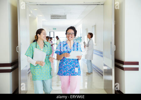 Lächelnde Krankenschwestern im Krankenhausflur sprechen Stockfoto
