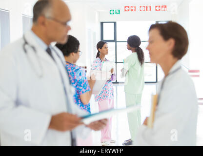 Ärzte und Krankenschwestern im Krankenhausflur sprechen Stockfoto