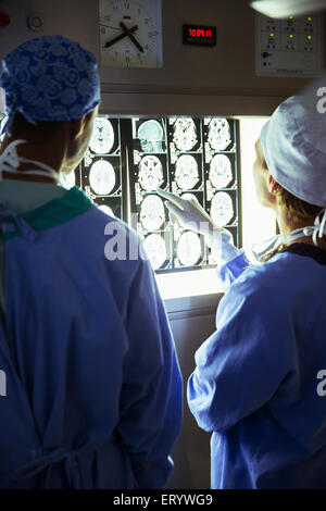 Chirurgen überprüfen und diskutieren MRI-scans Stockfoto