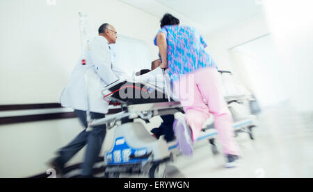 Arzt und Krankenschwester Patient auf Bahre im Krankenhausflur Rauschen Stockfoto