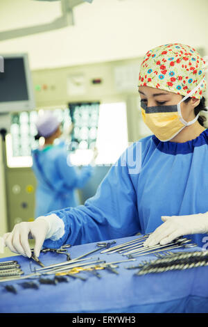 Chirurgen, die Vermittlung von Chirurgische Scheren auf Tablett im OP-Saal Stockfoto