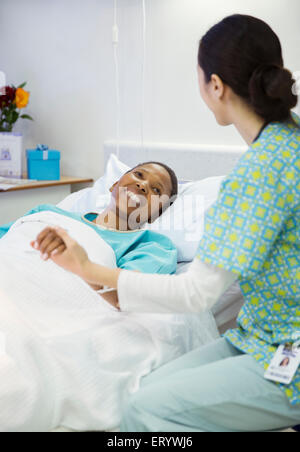 Krankenschwester, halten Hand lächelnd Patienten im Krankenzimmer Stockfoto