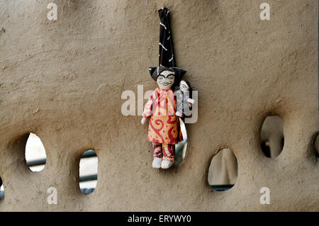 Mini Puppen Sachen hängen die Schlamm-Mauer; Bhuj; Kutch; Gujarat; Indien Stockfoto