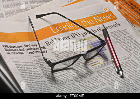 Zeitung mit Brille und Stift Stockfoto