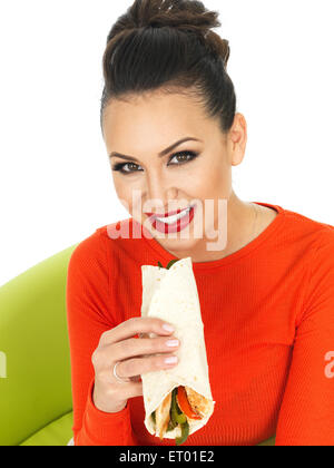 Schöne junge lateinamerikanische Frau mit einem mexikanischen Stil Chicken Fajita Wrap vor einem weißen Hintergrund Stockfoto