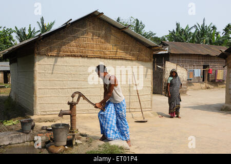 Mann mit Handpumpe im Dorf; Assam; Indien; Asien Stockfoto