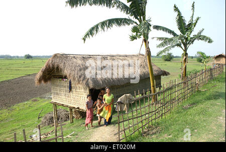 Familie vor Bambus Cottages im Majuli Insel; Assam; Indien NOMR Stockfoto