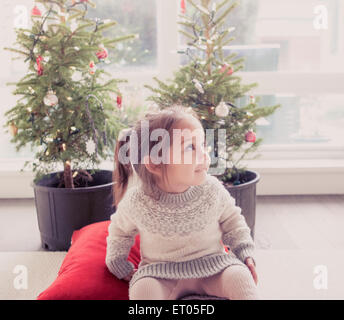 Lächelndes Mädchen vor eingemachten Bäume mit Weihnachtsbeleuchtung Stockfoto