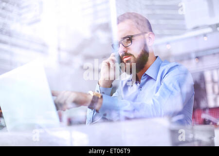 Geschäftsmann, reden über Handy und Laptop verwenden Stockfoto